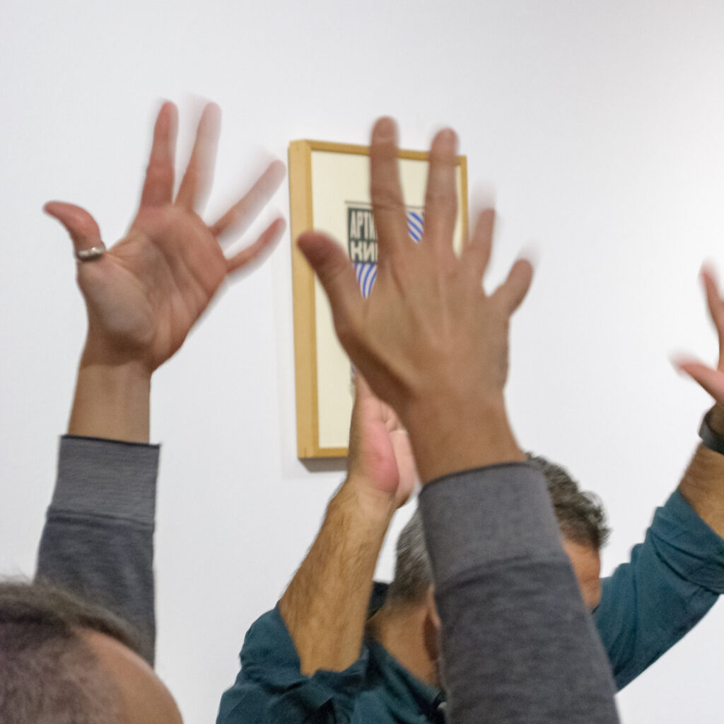 Hands in the air clapping in sign language.