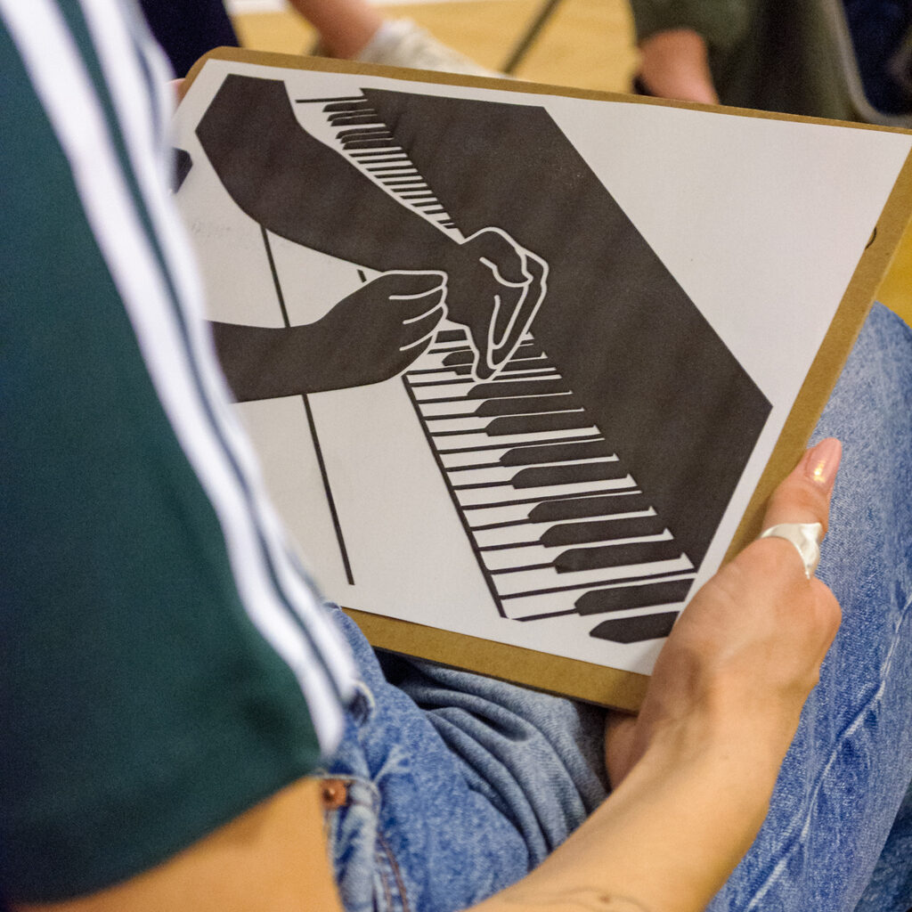 Hands hold the tactile representation of the artwork on Piaf print.