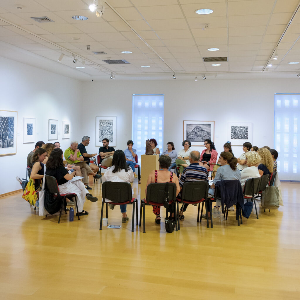 Μεγάλος κύκλος συμμετεχόντων ατόμων σε εκθεσιακό χώρο του ιδρύματος Τηνιακού πολιτισμού