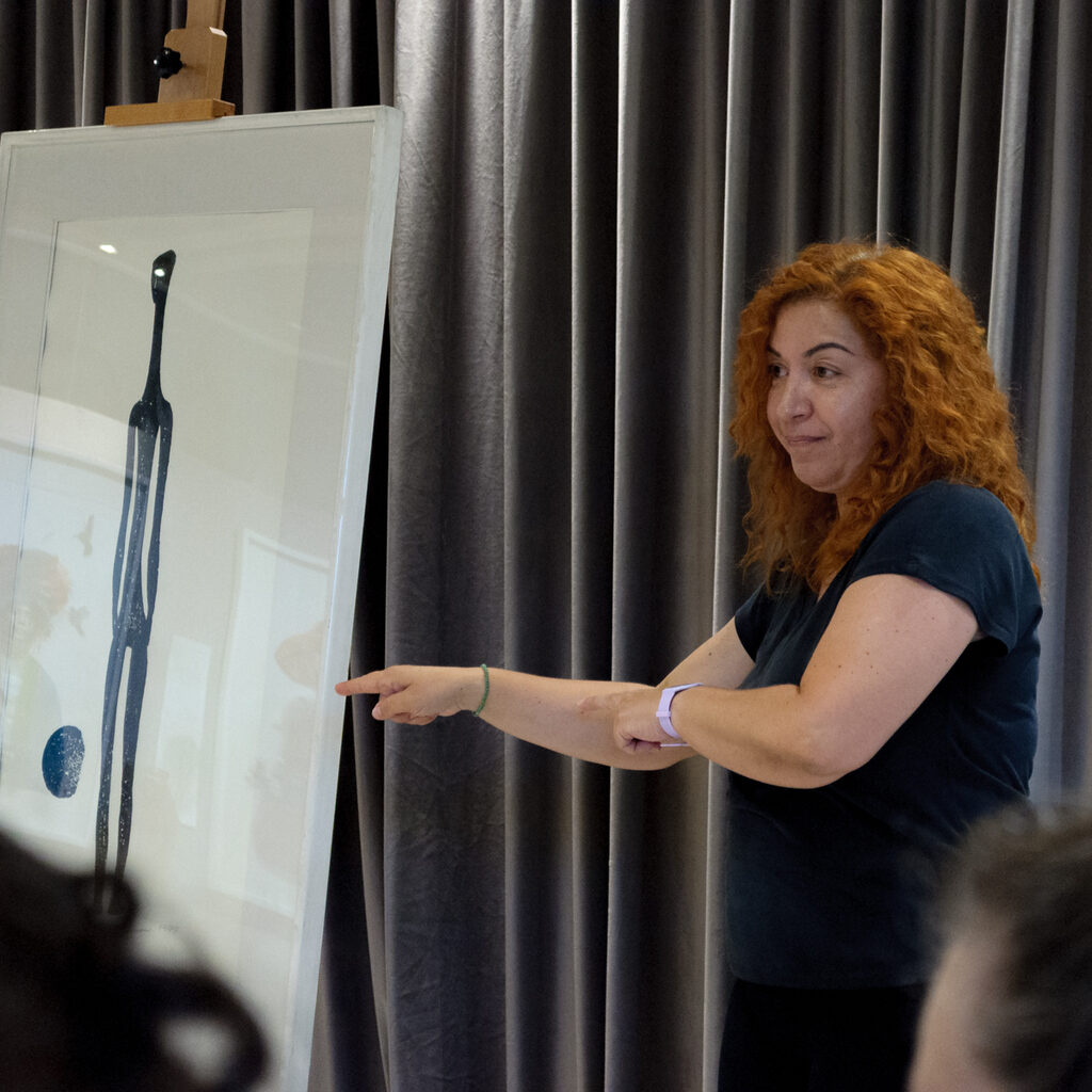 Woman pointing at artwork on an easel