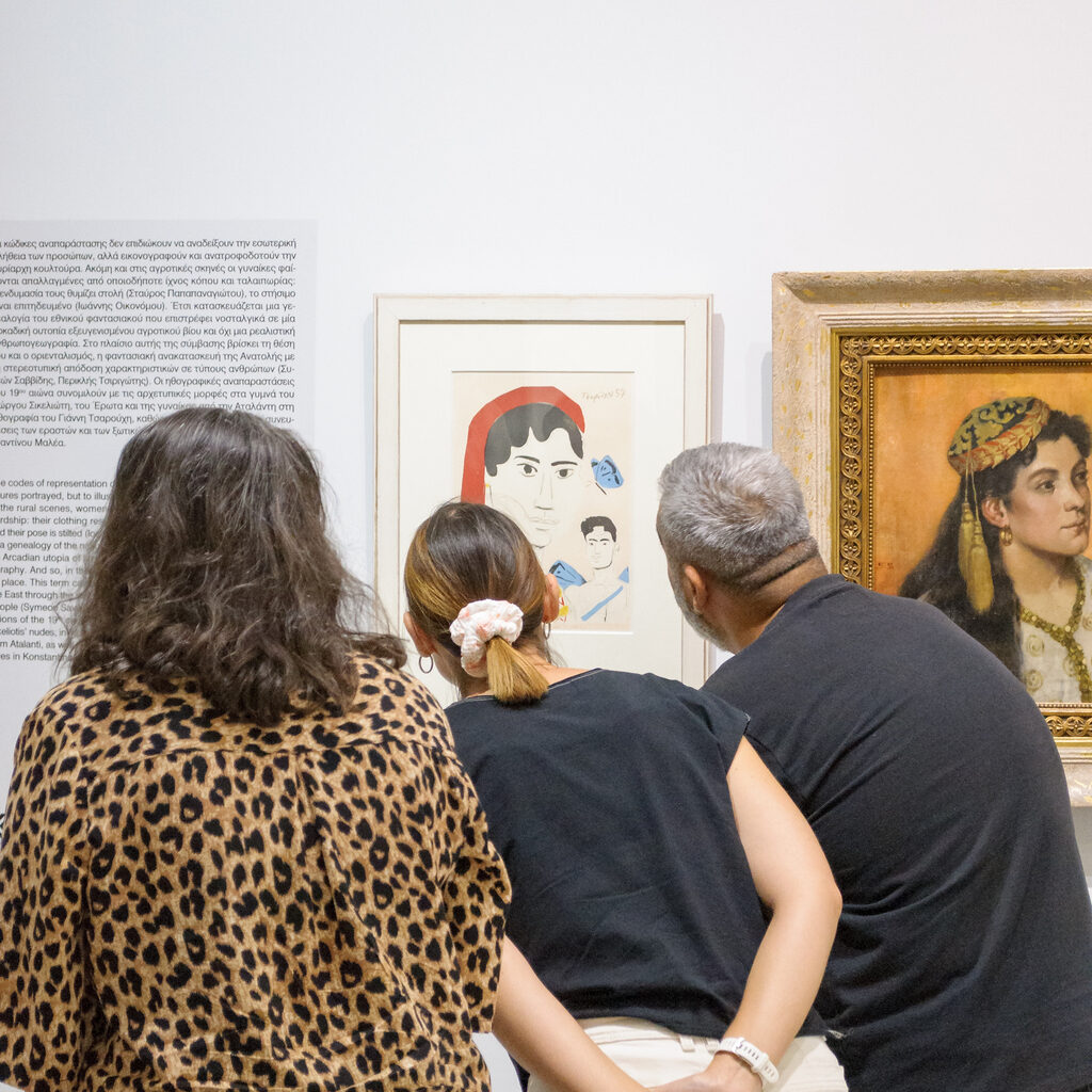 Three people observing a painting in a museum.