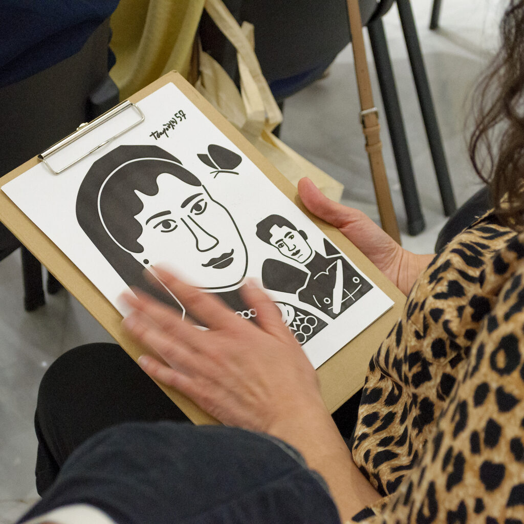 Hands exploring a tactile drawing on a board.