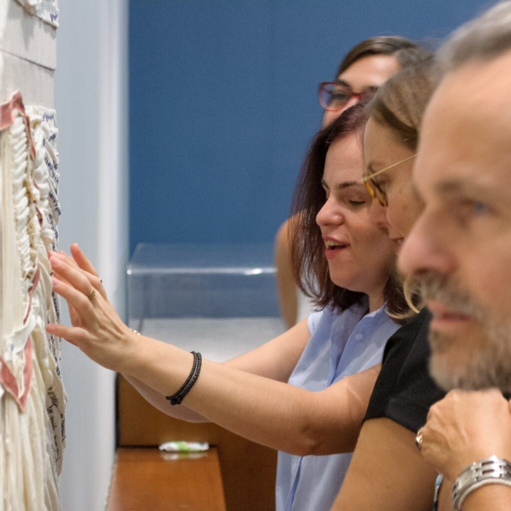 Participants touching a textile artwork..