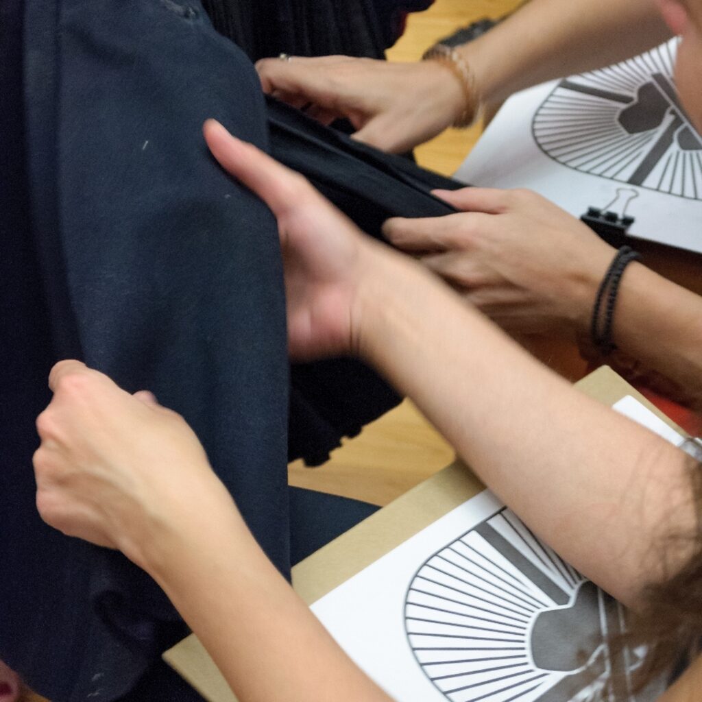 Hands exploring fabric through touch.