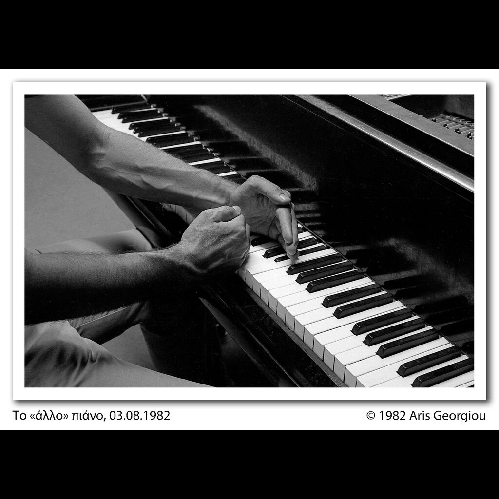 Black and white photo of hands over piano keys
