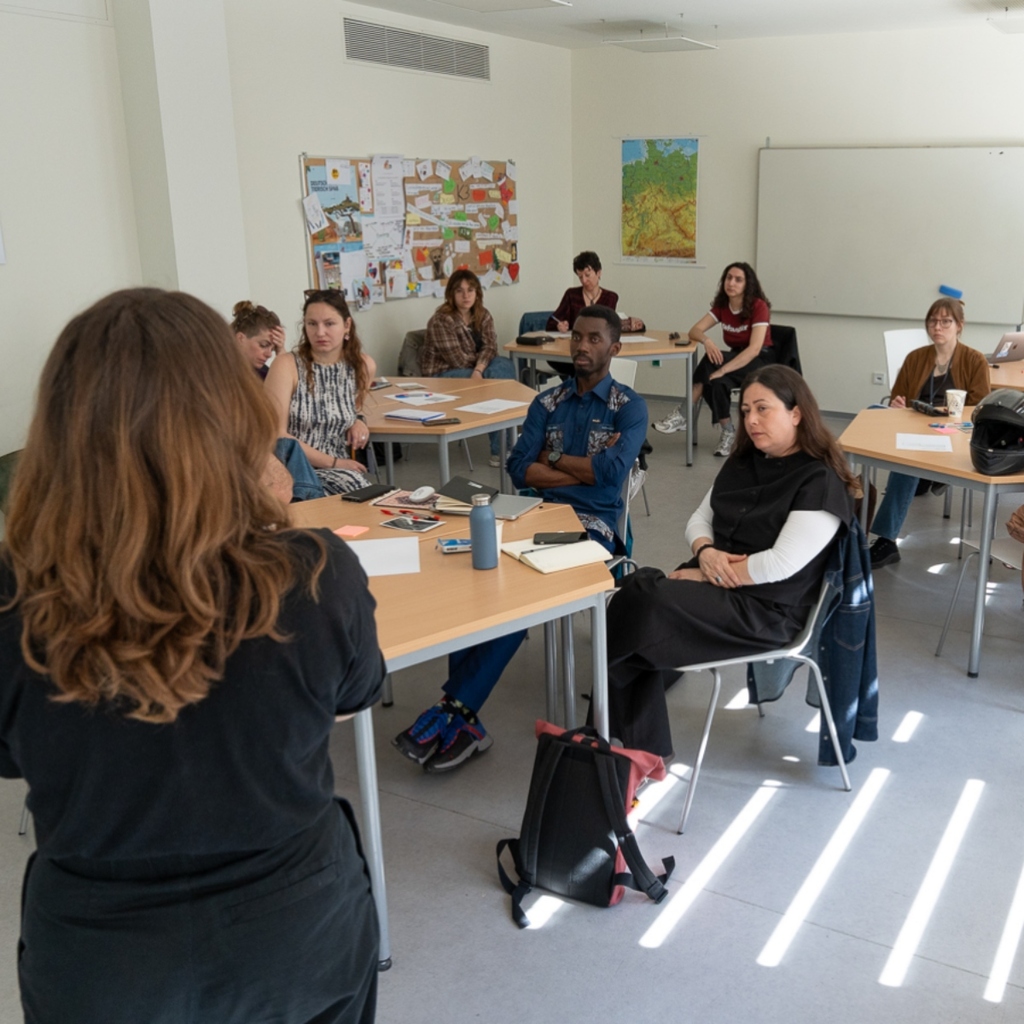 A group of people listen and discuss with the moderator during the workshop.