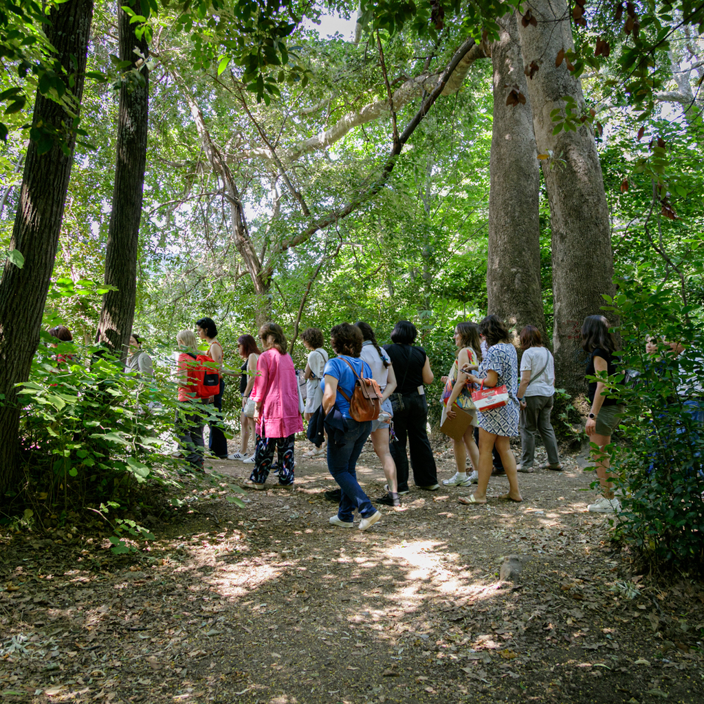 Group of participants walking through the lush greenery of the Historic Delasalle Garden.